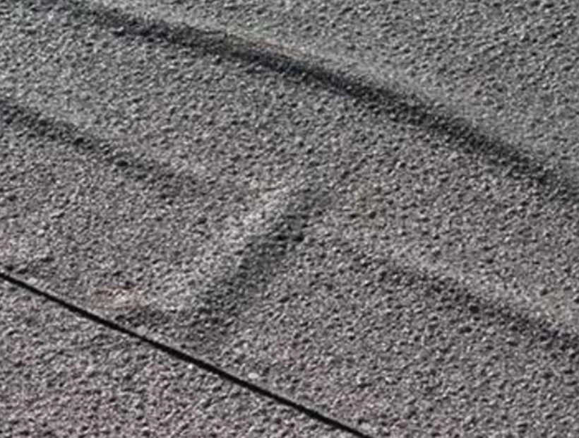 Membrane deformation caused by ridging in two-ply modified roof.